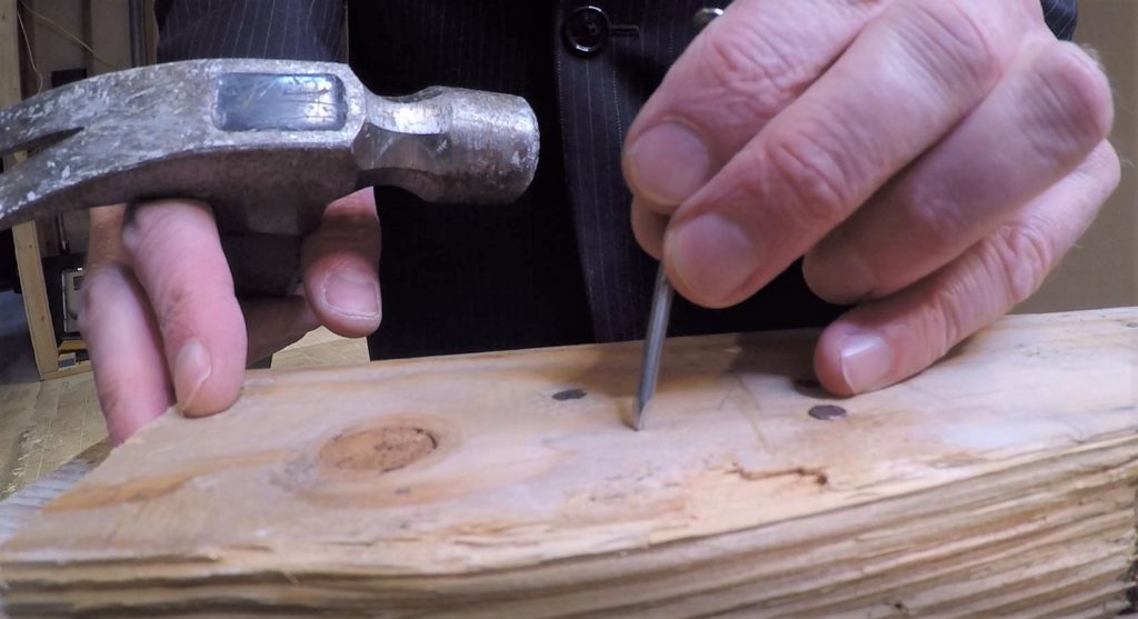 Setting Nail in Place Before Hammering It
